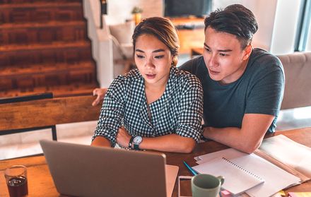 A young couple looking at their laptop