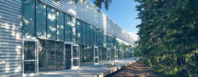 Exterior of an office building with benches and trees.