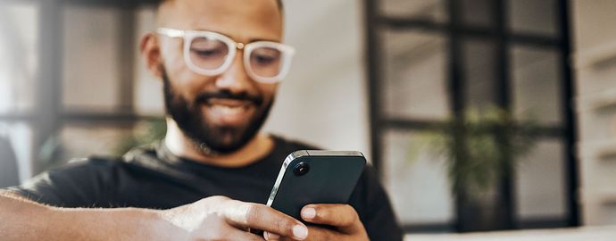 A man using a mobile phone to text.