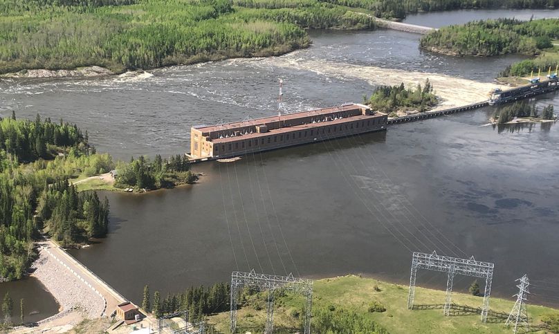 Eaux de crue encerclant les routes et la centrale hydroélectrique.