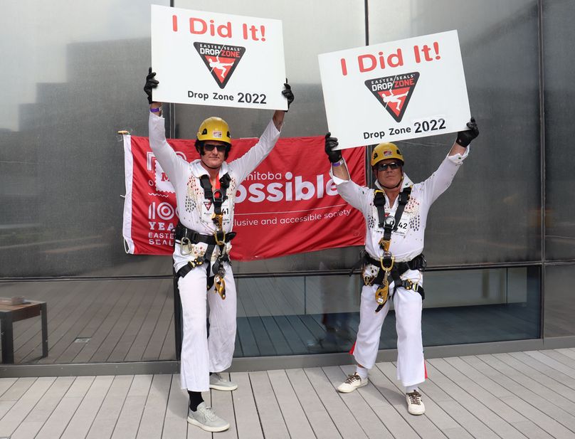 Two men in white polyester jumpsuits hold signs reading I did it.