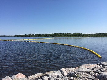 Safety booms mark dangerous water zones near spillway entrances.