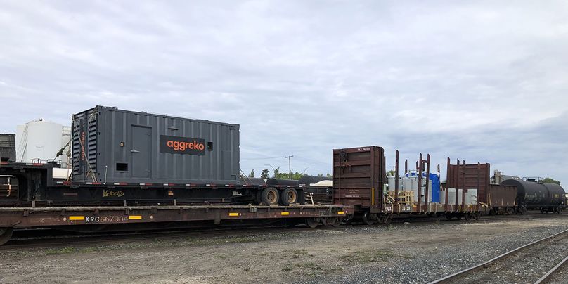 Un wagon de train surbaissé transportant un gros générateur de 1 500 kilowatts.